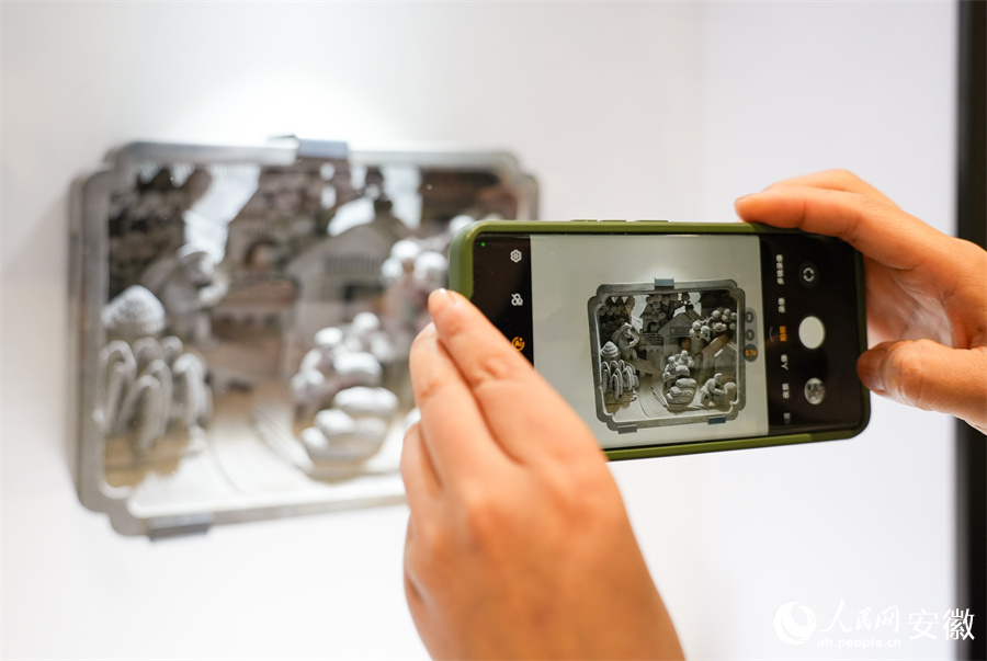 参观市民正在用手机拍摄石雕展品。人民网记者 王锐摄
