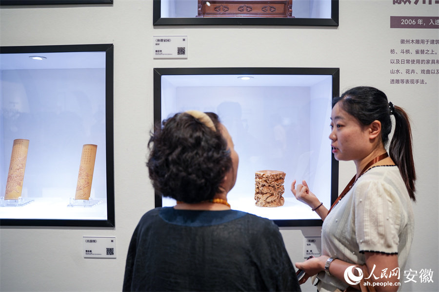 非遗传承人正在为参观市民介绍徽州木雕。人民网记者 王锐摄