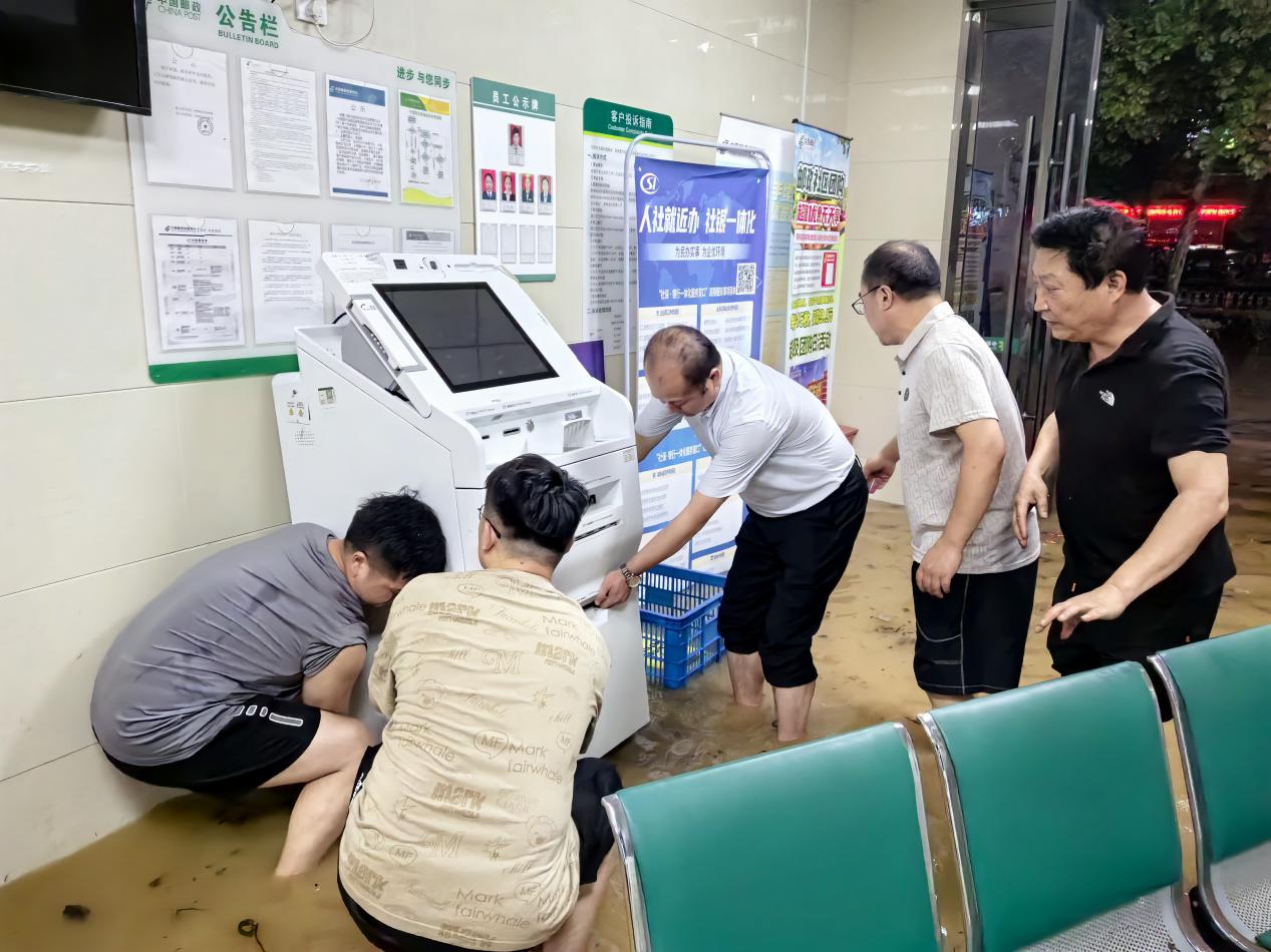歙县分公司防汛抢险先锋队正在百花路邮政支局转移ITM设备到安全地区。
