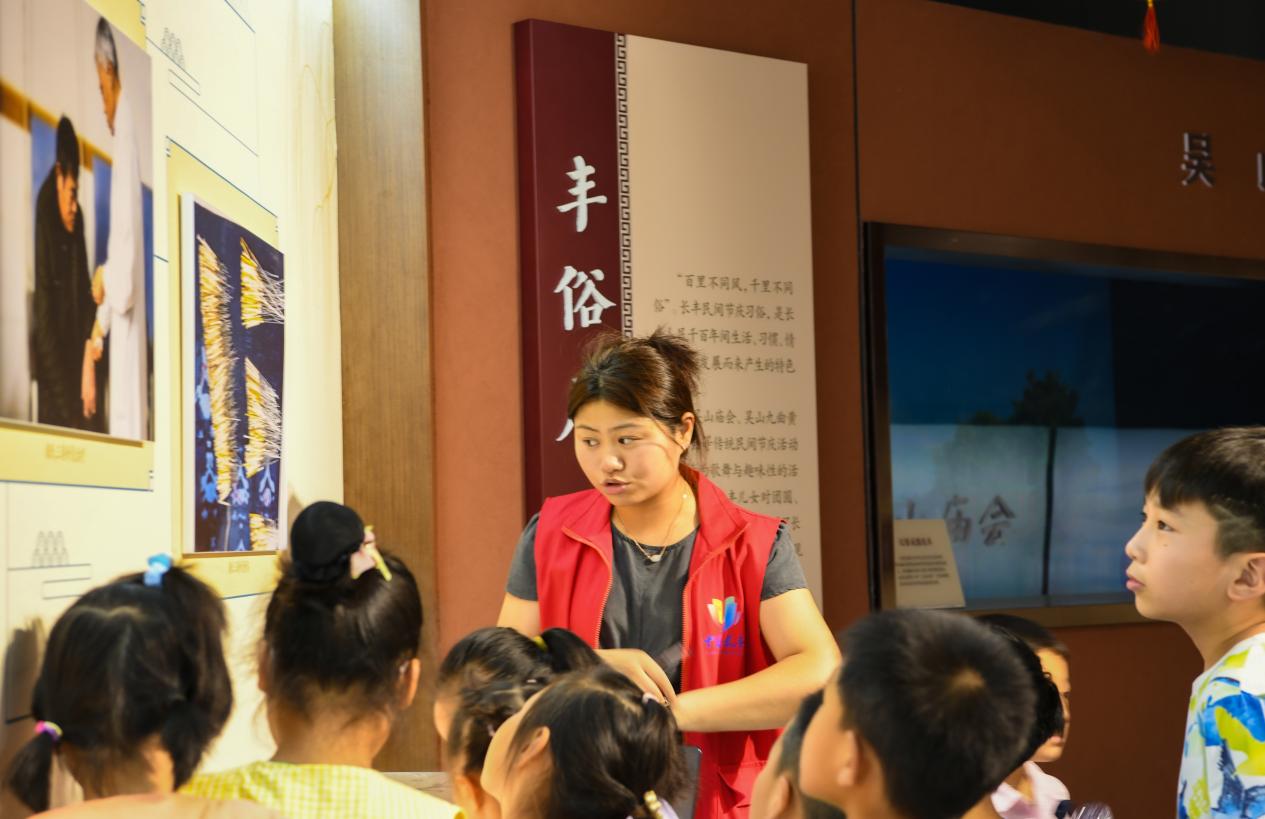 文化志愿者在长丰县非物质文化遗产展览馆内给学生做讲解