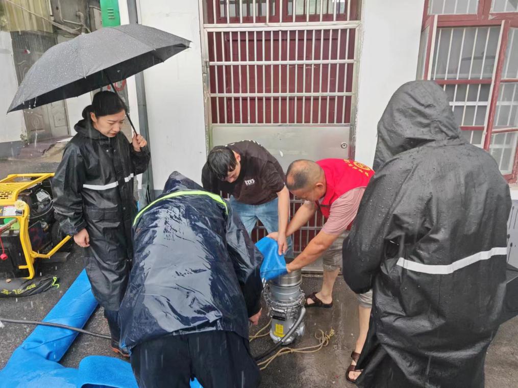 上派镇青年社区党委书记带领党员志愿者在内涝小区安装水泵紧急抽水排涝