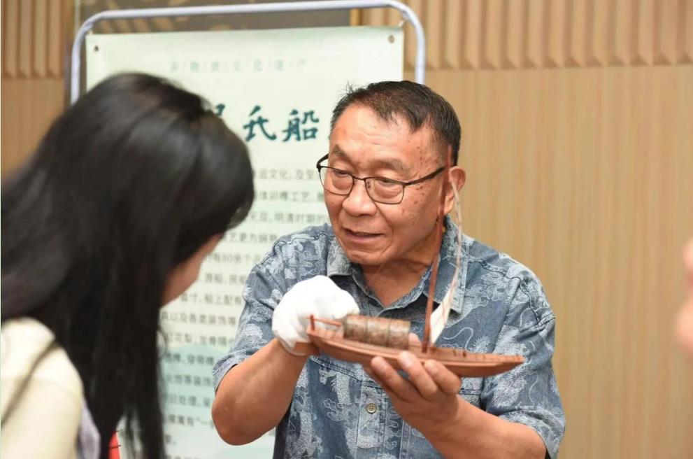 非遗传承人向与会人员展示非遗作品。