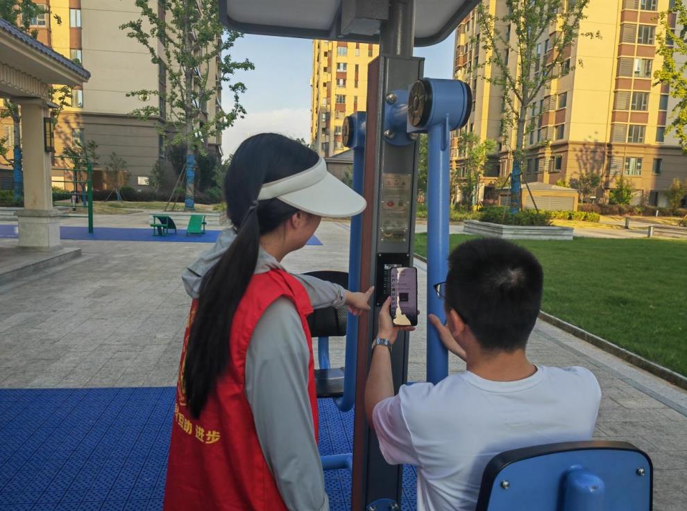 社区志愿者指导小区居民使用智能坐蹲器相关功能。