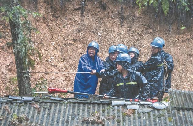 供電員工冒雨清理因山體滑坡倒伏的樹障。