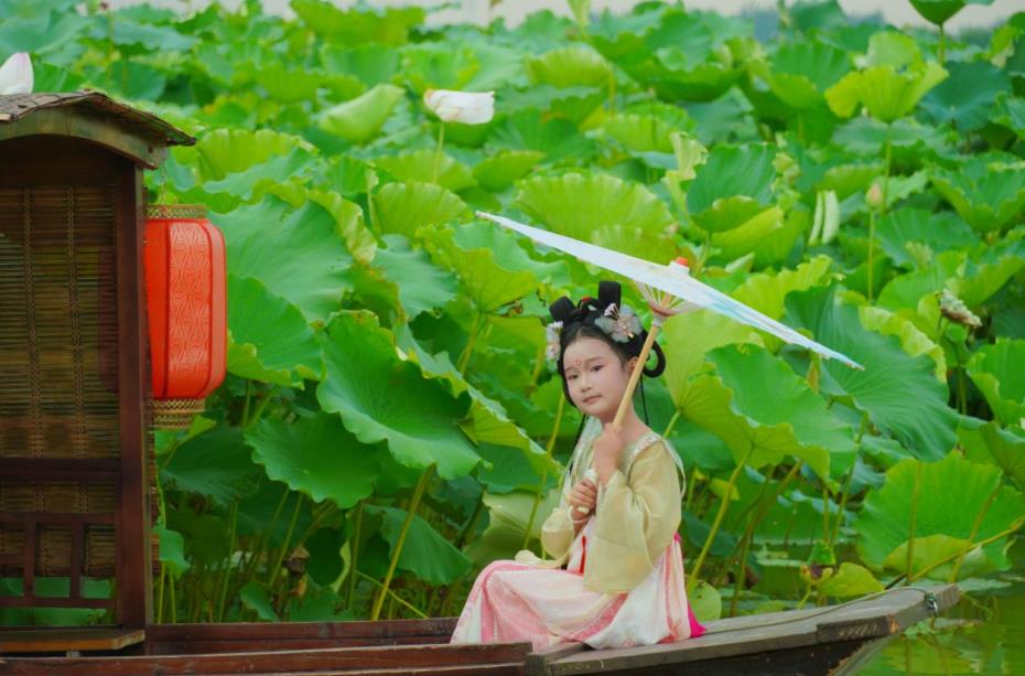 小朋友在游船上赏荷。李域摄