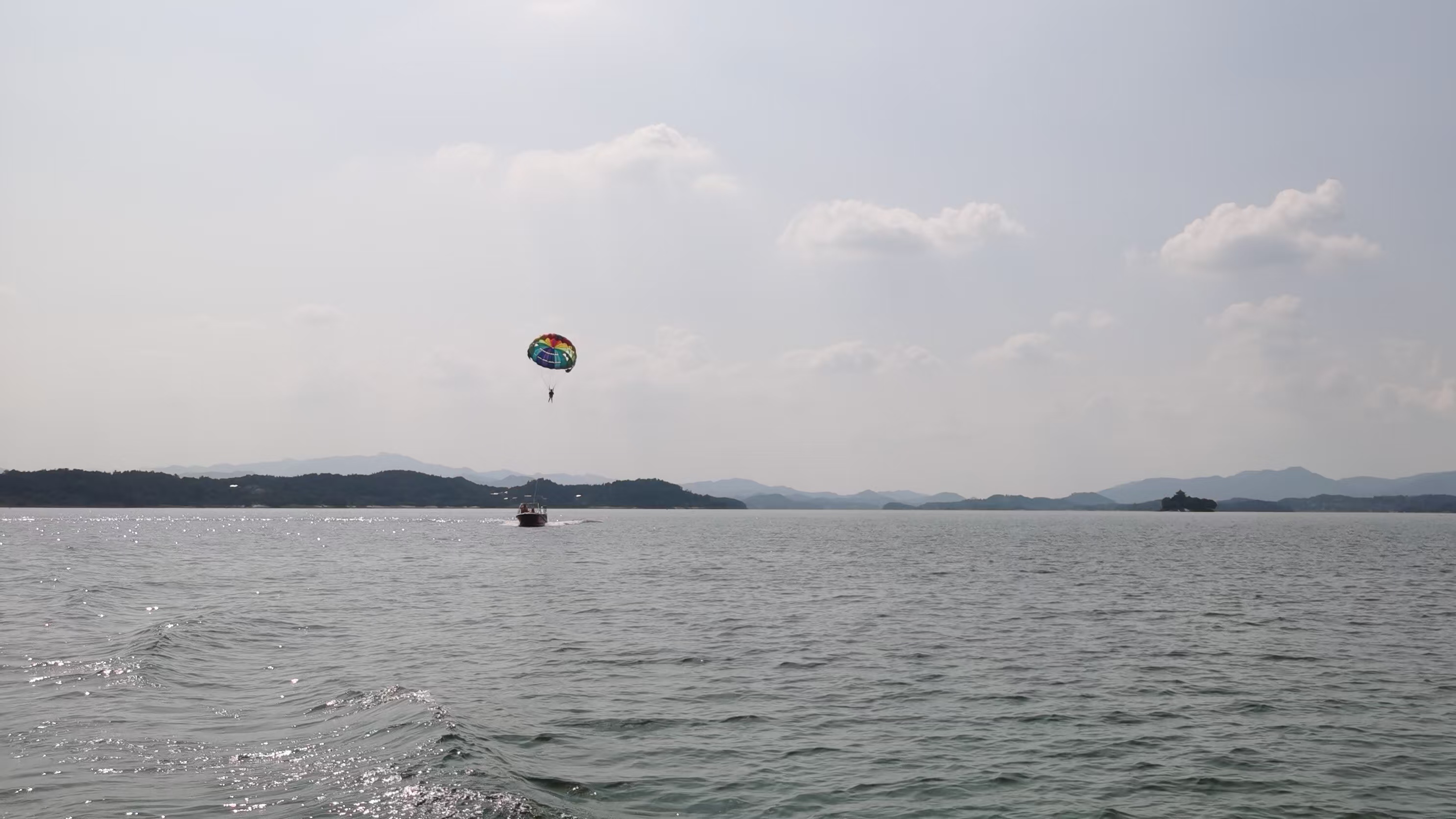 游客在湖面体验滑翔伞项目。人民网 胡雨松摄