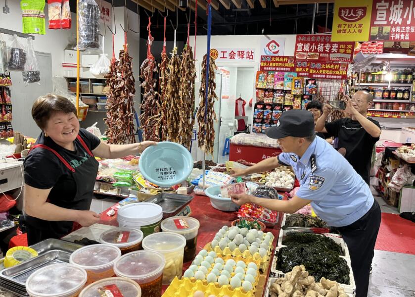 民警深入辖区农贸市场，近距离向商户开展假币宣传。汪阳 摄