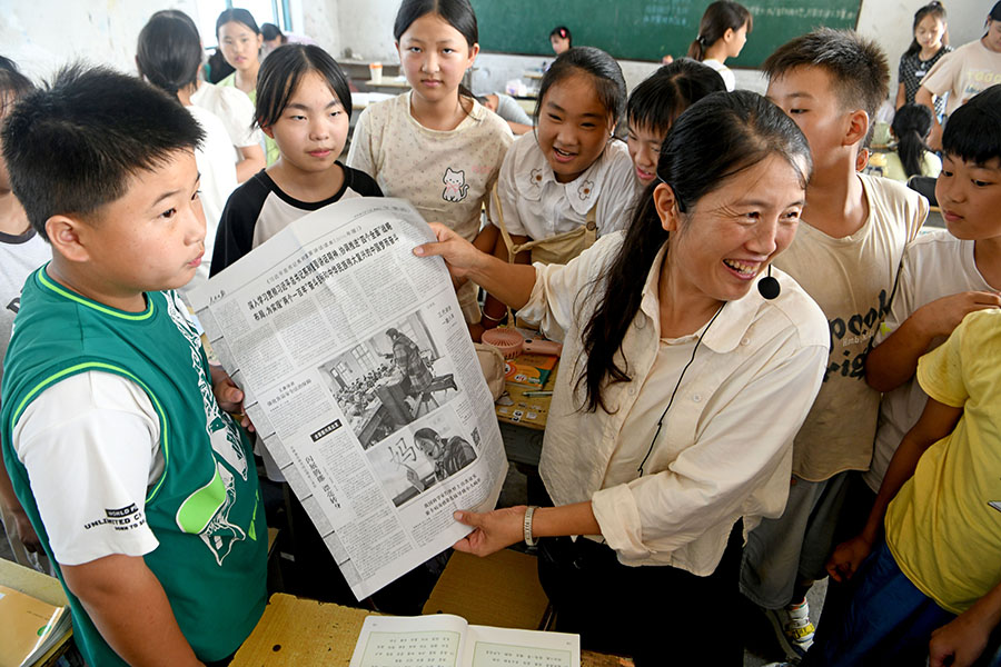 2024年9月9日，安徽省淮南市凤台县丁集镇张巷小学老师李元芳课下与学生分享《人民日报》8年前的新闻报道，介绍自己教育经历。