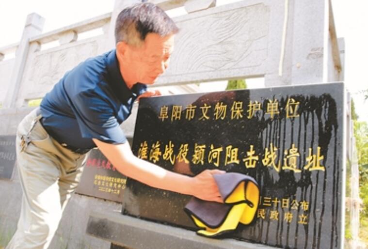 陈广安为纪念碑擦拭灰尘。