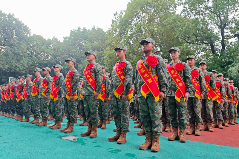 新兵们肩披“参军光荣”绶带,胸前佩戴着大红花。