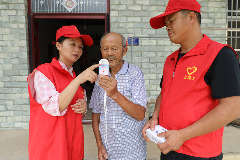枞阳县雨坛镇新民村村干部为独居老人演示“一键呼”设备操作。铜陵市委政法委供图_proc.jpg