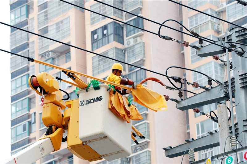 9月26日，在利辛縣城區淝河路與前進路交叉口，國網利辛縣供電公司帶電作業員工正在220千伏子胥變10千伏世紀2號線2D8線淝河路支線37+1號杆進行帶電懸空搭火前的絕緣遮蔽工作。（劉喆）