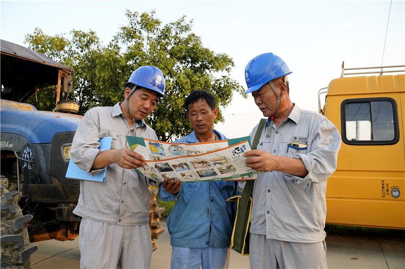 圖2、9月30日，國慶節在即，安徽滁州定遠縣供電公司池河供電所員工房付明、姜廣杰、王明喜堅守崗位，向農機手宣傳線路設備防外破知識，護航秋收季供電安全（吳傳訓）。