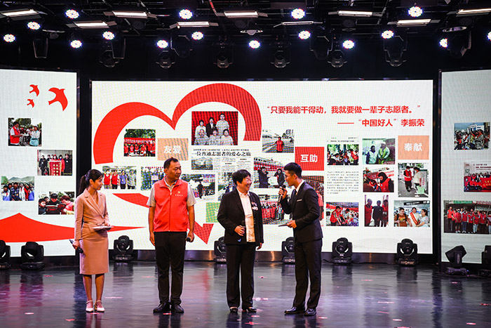 李振荣右（二）在展示她事迹的舞台上，接受采访