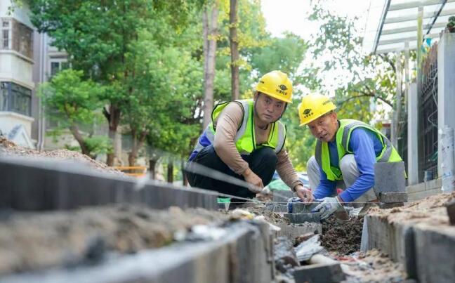 在奧林花園一期小區，工人正在鋪裝路面。