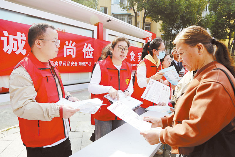 机关党员志愿者们向阳湖社区居民宣传食品安全法律法规。