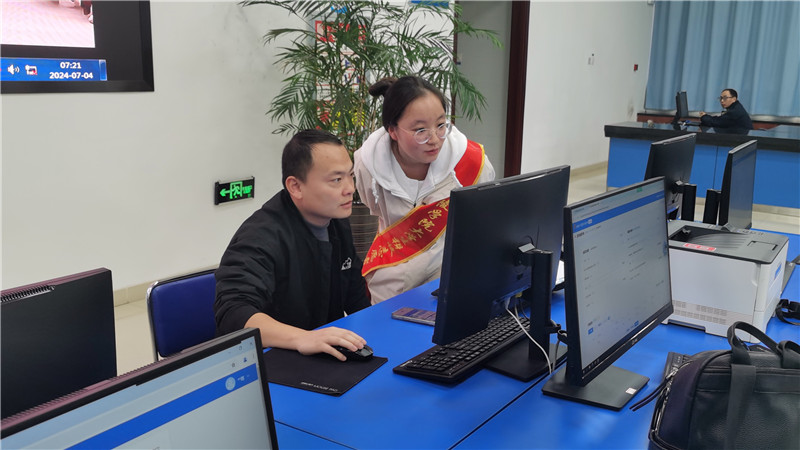 铜陵市税务局办事大厅内，志愿者协助市民办理业务。人民网 胡雨松摄