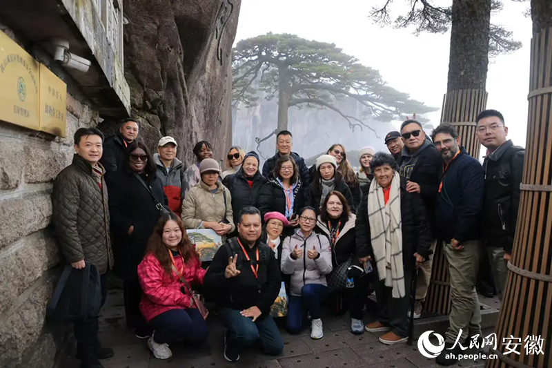 旅行商在黃山迎客鬆前合影。人民網記者 王曉飛攝