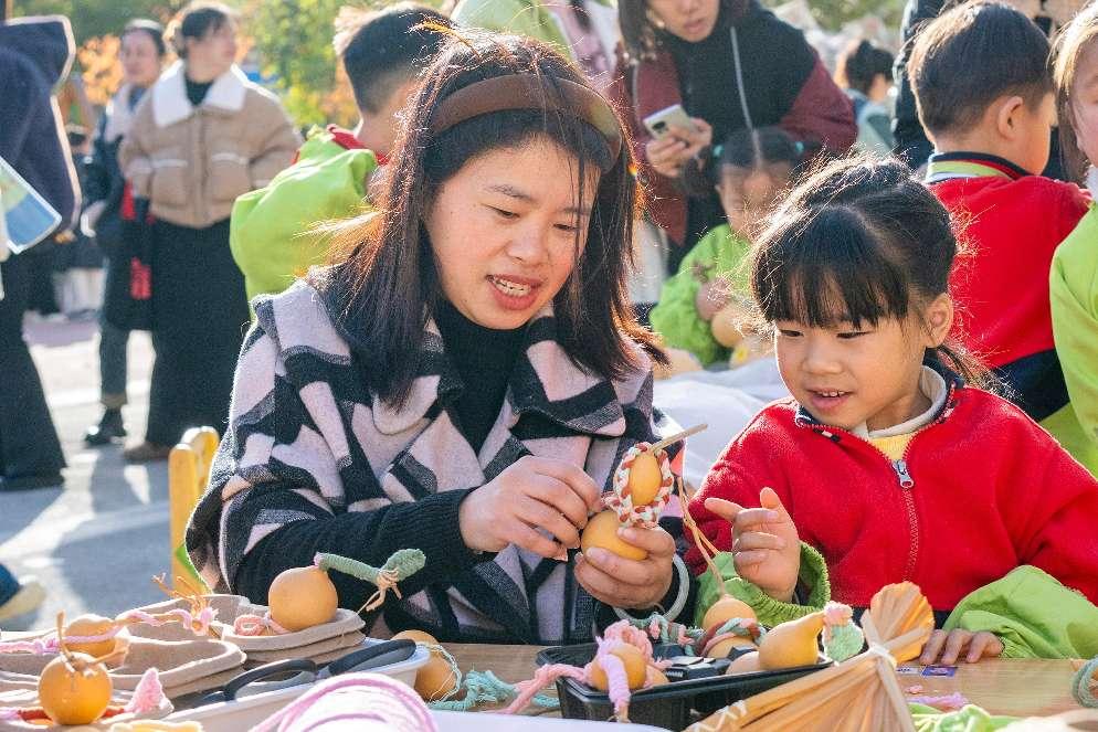 孩子教妈妈装饰秋天丰收的葫芦