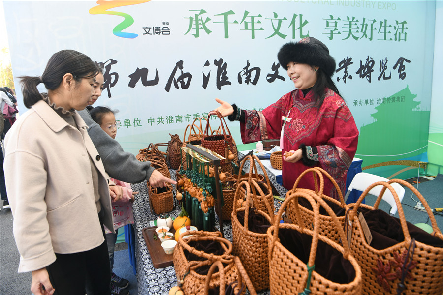 淮南市民在第九届淮南文博会现场了解藤编技艺。