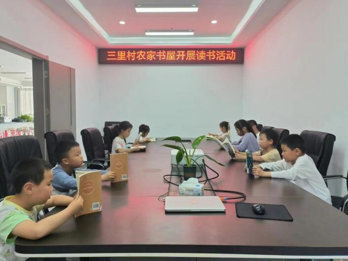 农家书屋管理员组织周边儿童开展读书活动。