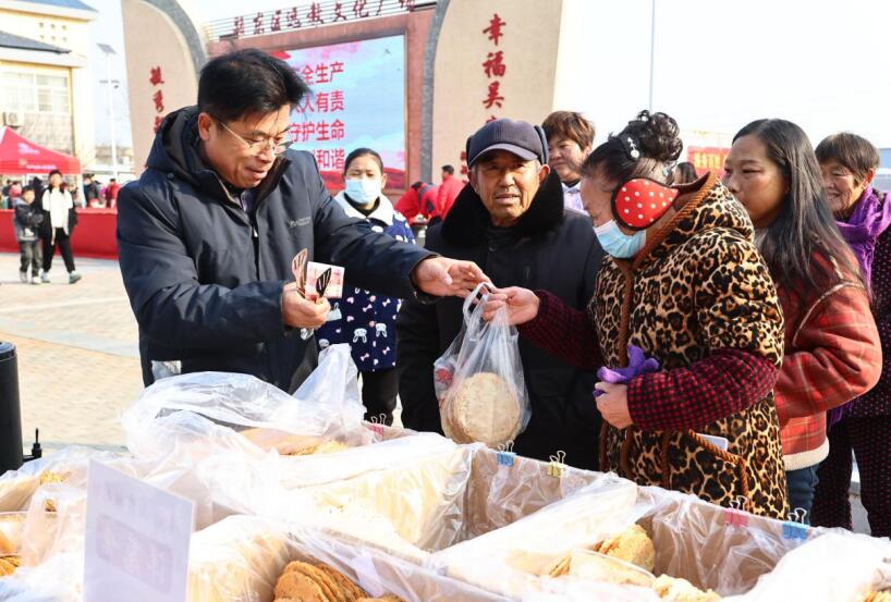 村民在集市上购买商品。张蕊摄