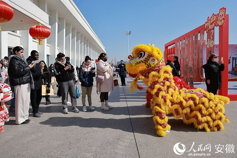 几位外国友人用手机记录下舞狮表演的精彩时刻。人民网记者 王晓飞摄