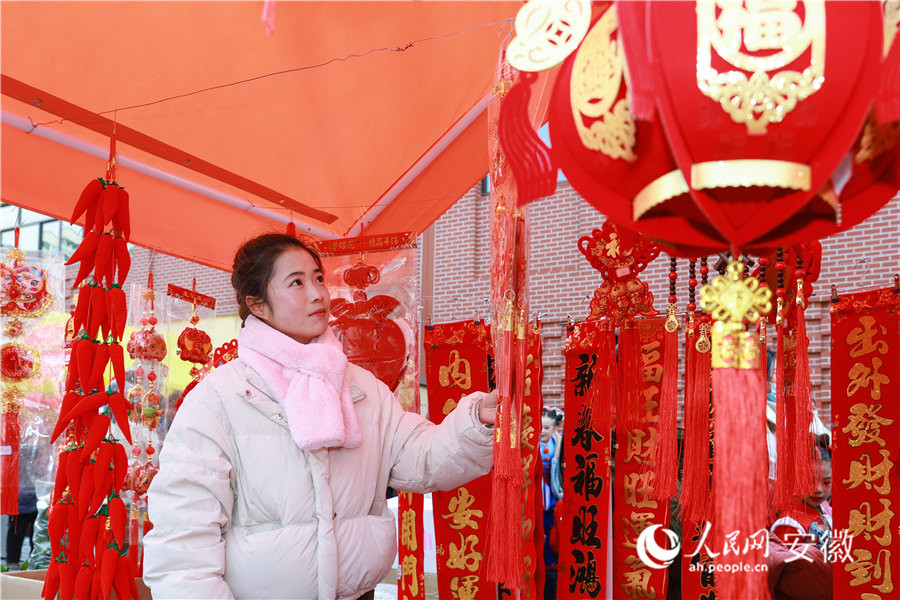南陵年货集市，居民挑选新年装饰品。人民网记者 张俊摄