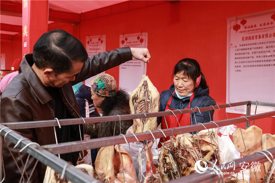 南陵年货集市，居民挑选腊味。人民网记者 张俊摄