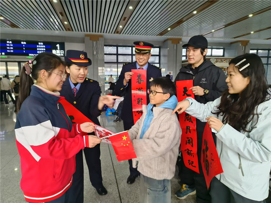 车站工作人员和特教中心学生为旅客送上春联、剪窗花和祝福。