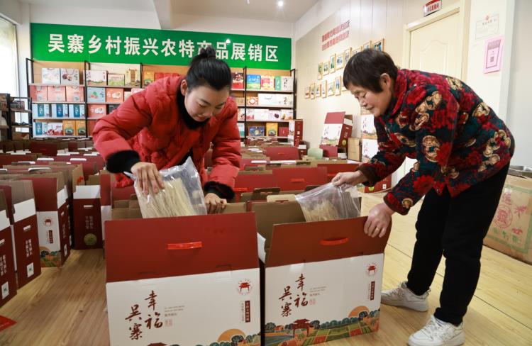 王双双和婆婆正在给农产品打包装箱。张蕊摄