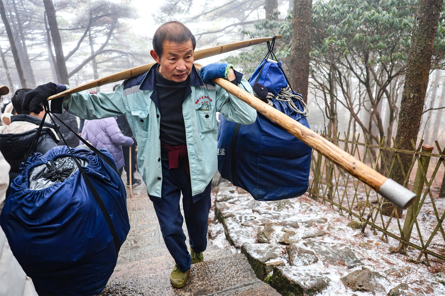 2月2日，大年初五，黄山挑山工冒雪向山上运送物资。