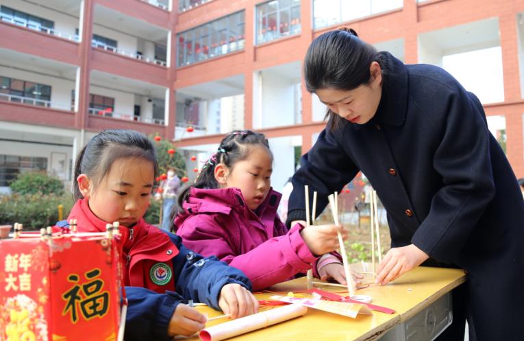 同学们在老师指导下制作花灯。