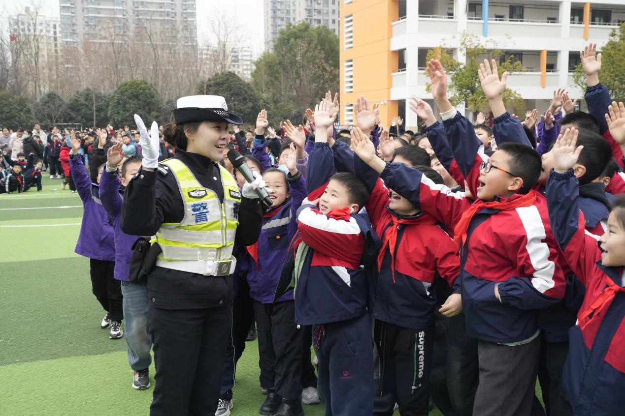 交警在和育新小学的学生们进行趣味交通安全知识有奖问答。