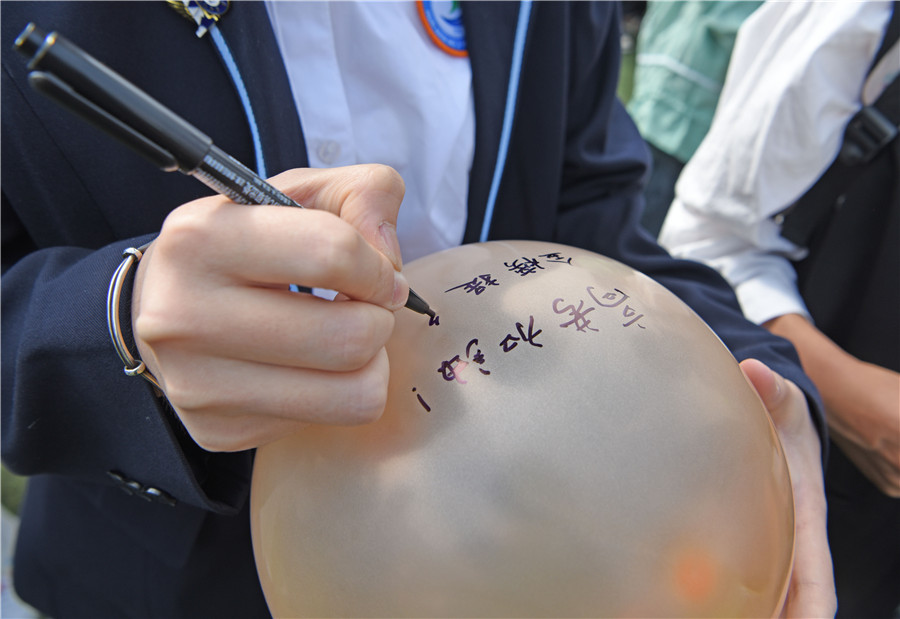 高三學生在夢想氣球上寫下高考加油、金榜題名的夢想。