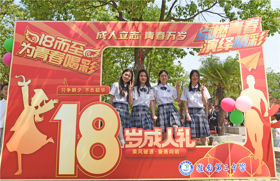 高三學生在十八歲成人禮展板前合影留念。