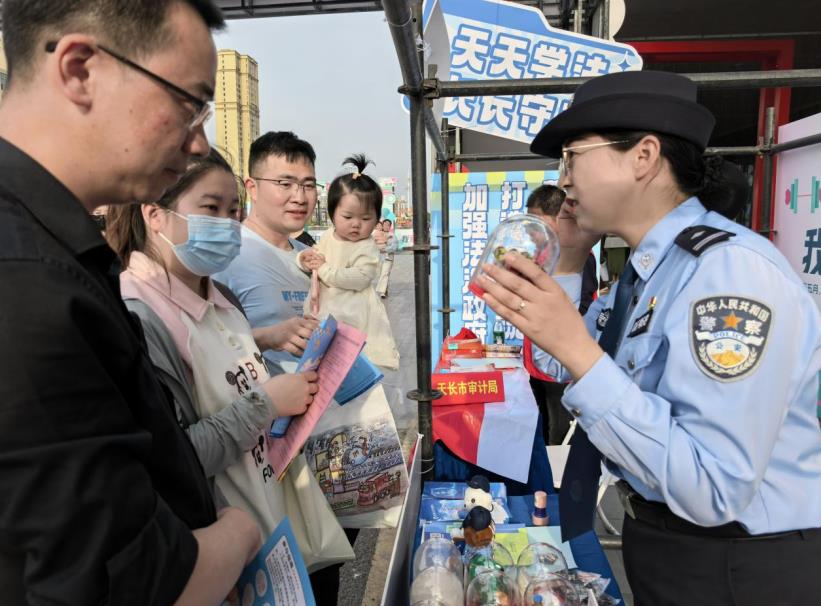 禁毒民警在商圈結合毒品仿真模型向群眾講述非法種植罌粟的危害。田宇攝