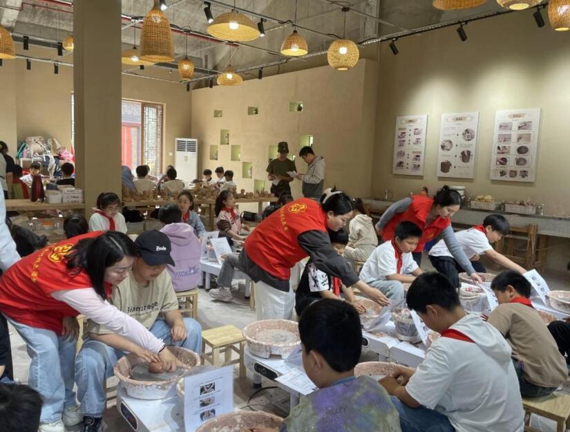 志愿者和孩子们一起创造陶艺作品。