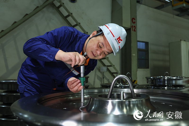 沈飛在車間測量車輪輻板孔直徑。人民網記者 張俊攝