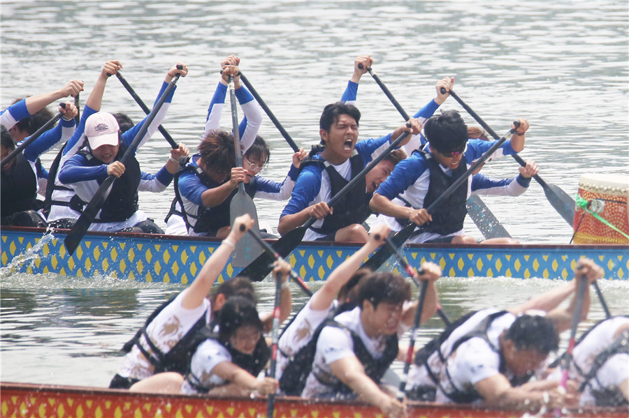 大學生在比賽中奮力劃槳。陳東攝