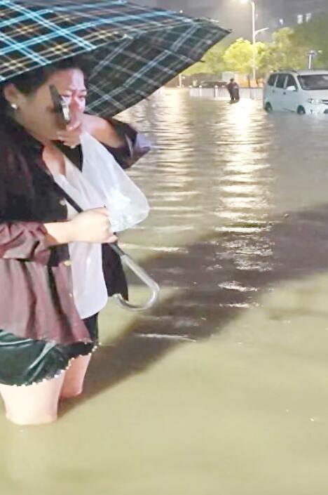 跌落下水道脱险后，惊魂未定的程女士哭着坚持站在原地提醒路人绕行。