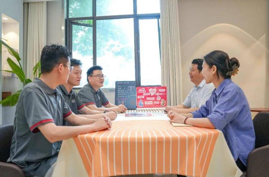 在蜀山区蜀麓苑社区党群服务中心内，几位快递小哥与社区干部围坐畅谈。