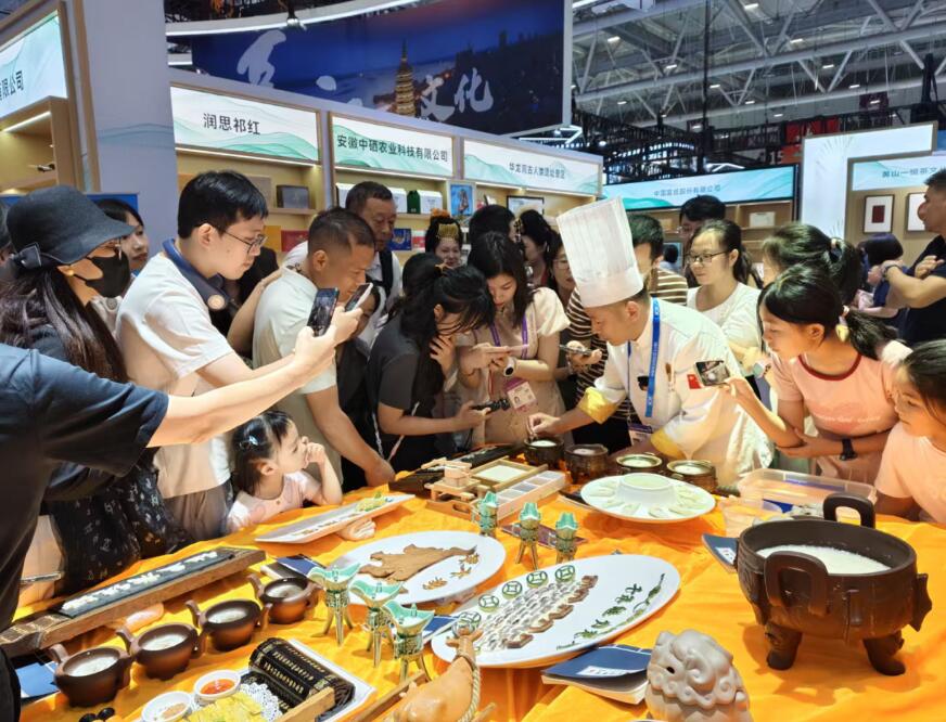 展会期间张士宏向观众展示豆腐宴制作技艺。王友唐摄