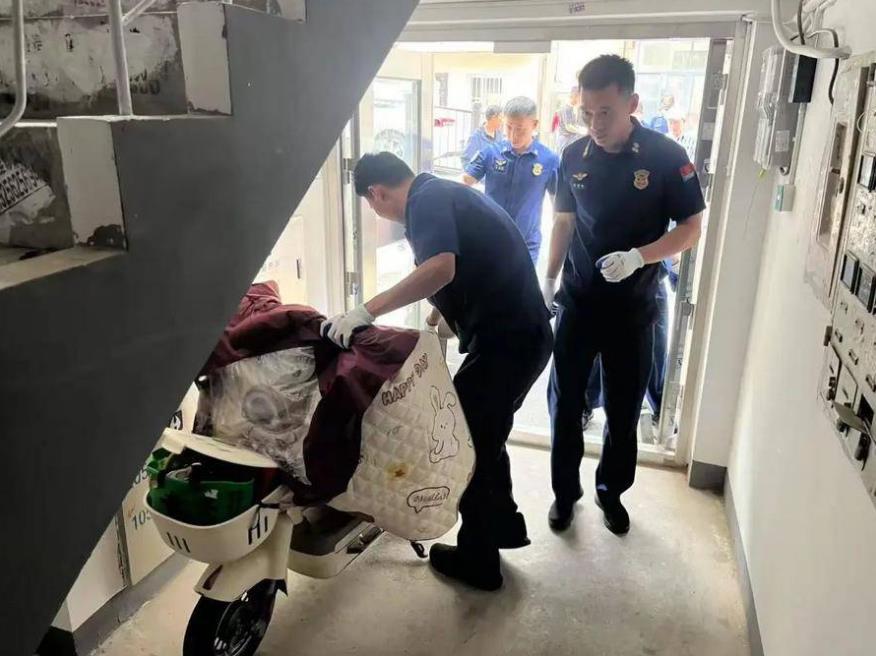 志愿者清理单元楼道乱停放车辆。