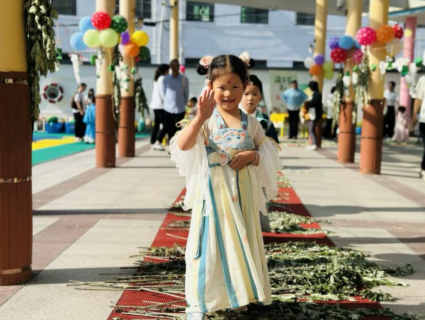 徽州區示范幼兒園內，身著華美漢服的孩子走在艾葉路上。