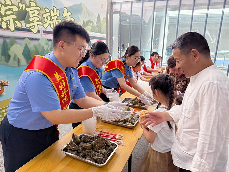 蚌埠站工作人员赠送粽子给乘客。孟婧雅摄