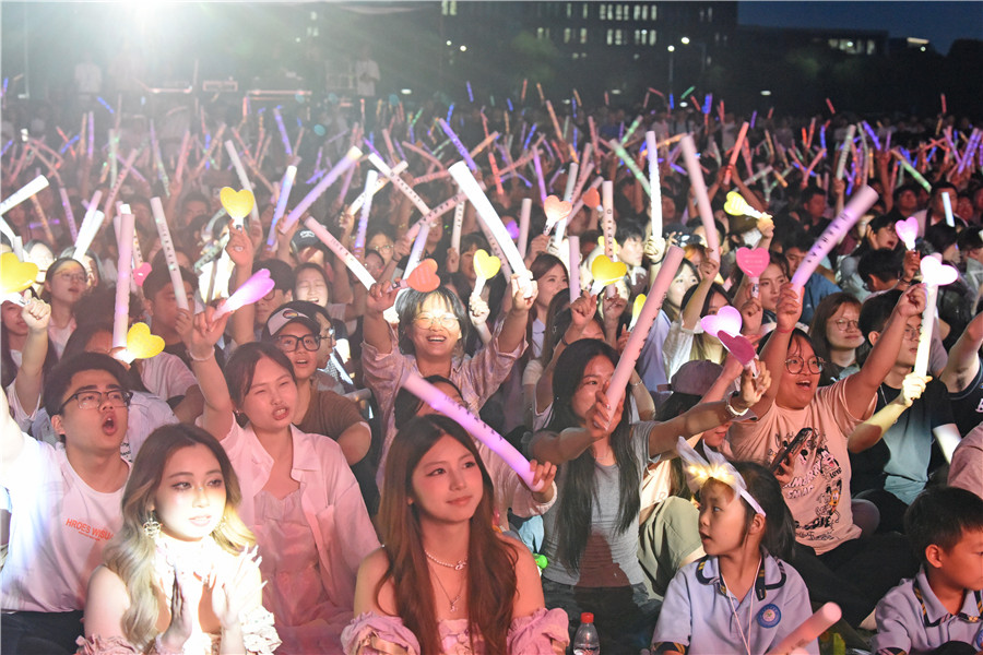 安徽理工大学大学生在校园“草地音乐节”上享受音乐。