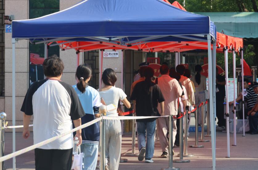 在颍上四小考點，考生依次通過安檢門進入考場。