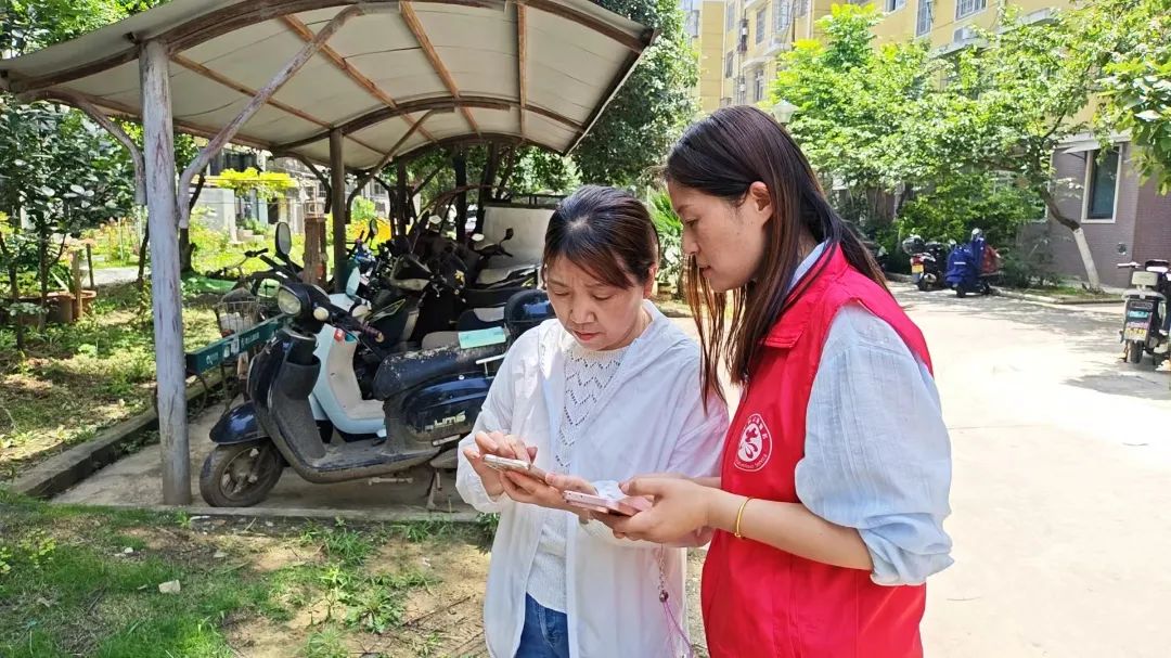 网格员在指导居民使用“随手拍”。合肥高新区供图