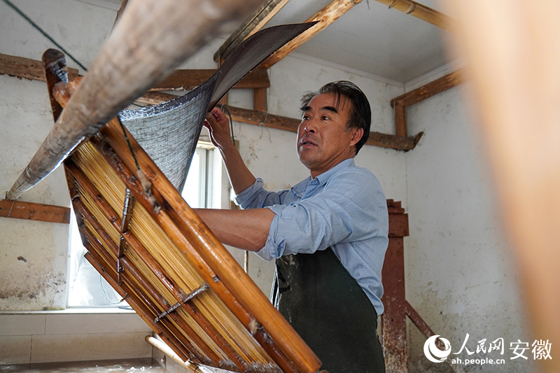 王柏林在捞纸。人民网记者 陈若天摄